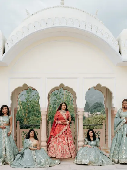 The bride with her bridesmaids, a portrait of friendship and support. The coordinated outfits and the beautiful palace setting make this a cherished memory.