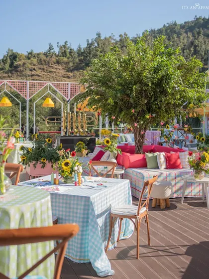 The combination of checkered tablecloths, wooden chairs, and a mountain view perfectly captures the chic picnic vibe.