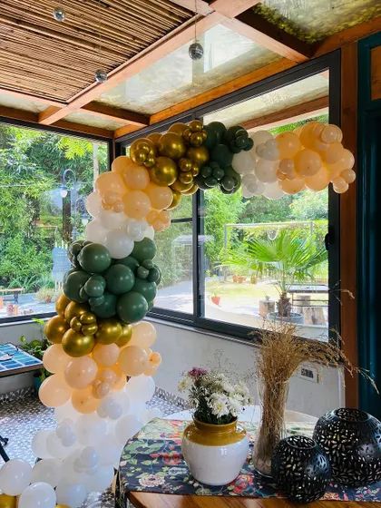 A high-angle shot showing the full curve of the rustic-themed balloon arch.