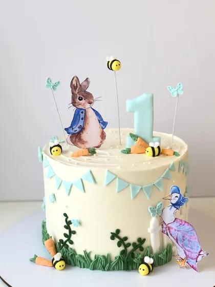 A charming Peter Rabbit cake for a first birthday. This design captures the gentle, storybook feel of the classic tales with delicate details and soft colors.