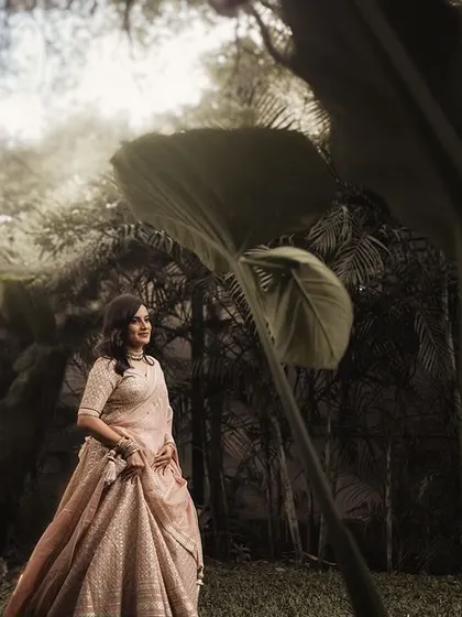 A bride walking through a lush, green landscape. The edit gives this image a timeless, film-like quality, enhancing the romantic and natural feel.