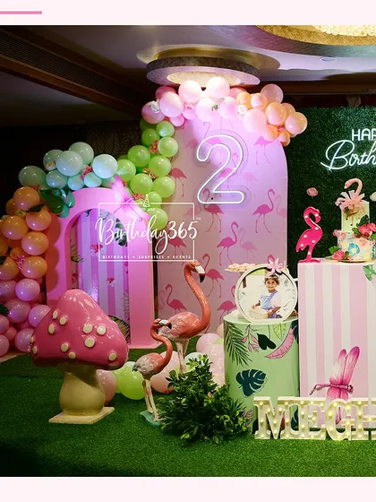 A fun and vibrant flamingo-themed party, featuring a "Happy Birthday" neon sign, striped pedestals, and plenty of pink flamingo props.