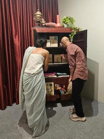 A moment of discovery at our exhibition. We design spaces that invite curiosity, like this antique cabinet filled with smaller artworks and objects, encouraging visitors to look closer and engage with the narrative on an intimate level.