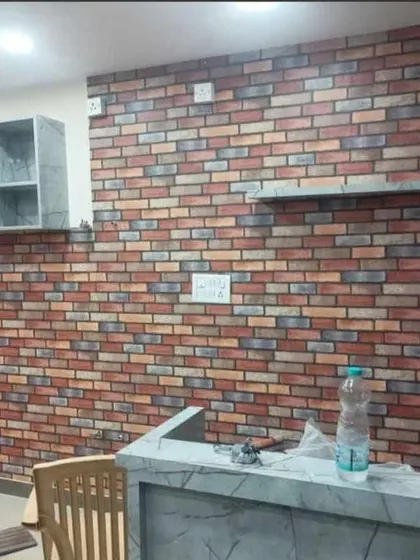 A multi-colored brick wallpaper adds an urban, rustic feel to this kitchen or bar area. The varied tones in the bricks give it a realistic, weathered look.