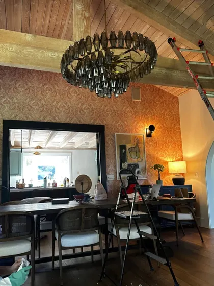 A work-in-progress photo of the dining area in the Saratoga home. You can see the chandelier being installed, a key moment in bringing the whole space together.