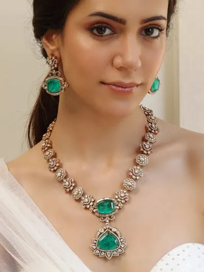 A simple yet elegant necklace from the Emrosia collection, with a single line of floral motifs set with emeralds and polki diamonds.