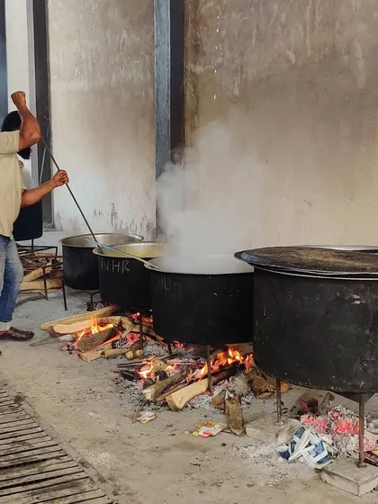 Our chef stirring a large pot of biryani over a wood fire. This hands-on, traditional cooking method is what sets our food apart and ensures a truly authentic taste.