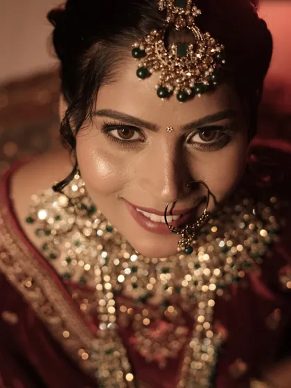 That look of pure happiness. This is a close-up of my bride, showing her glowing skin, soft brown smokey eye, and traditional nath. I always make sure my brides feel confident and beautiful.