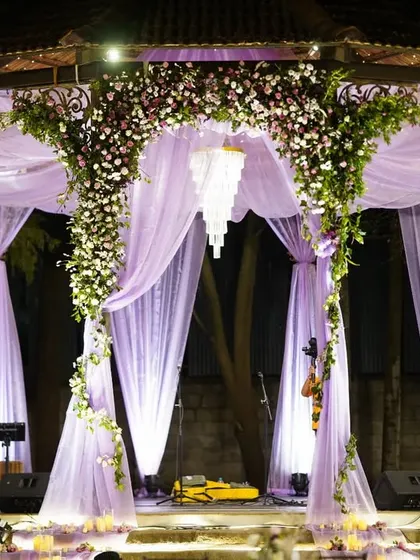 A dreamy combination of lavender drapes and a sparkling crystal chandelier. This decor element creates a soft, romantic, and utterly magical ambiance for an evening celebration.