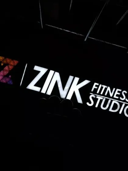 The Zink Fitness Studio sign glowing in the dark. It represents a beacon for health, wellness, and community in the neighborhood.