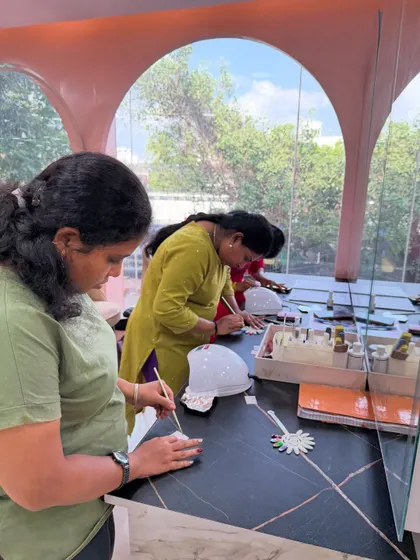 Students practicing intricate nail art designs with fine brushes during a weekend batch session.