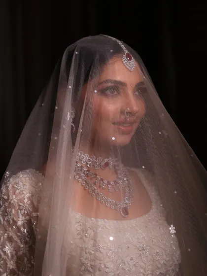 A dreamy shot of the bride under her veil. The soft focus and her serene expression create a truly magical and timeless bridal portrait.