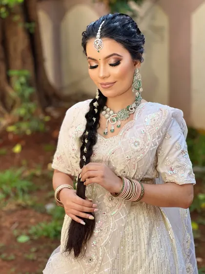 This image highlights the intricate details of the white bridal look, from the delicate maang tikka to the soft contouring and perfectly blended eyeshadow, all achieved with airbrush techniques.