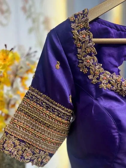 A close-up of the sleeve, showing the intricate, multi-colored embroidery that gives it a rich, textured look.