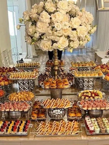 A lavish buffet spread featuring a huge variety of savory bites, from mini burgers to canapés. I work with top caterers to ensure the food is as impressive as the decor.