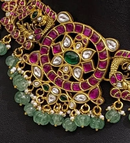A detailed shot of the peacock and floral motifs on the Jadau choker.