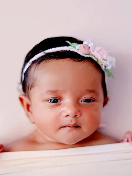 A cute 'peekaboo' shot of an awake baby looking over a soft blanket.