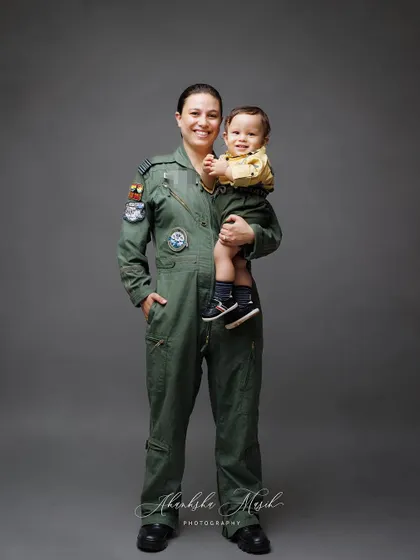 A strong and loving portrait of an Airforce mother with her son. Her smile shows the joy she finds in both her career and her family.