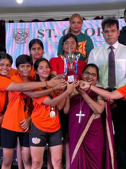 The team celebrates with their school principal and staff, holding the runners-up trophy. This shows the strong support system behind our players' success.