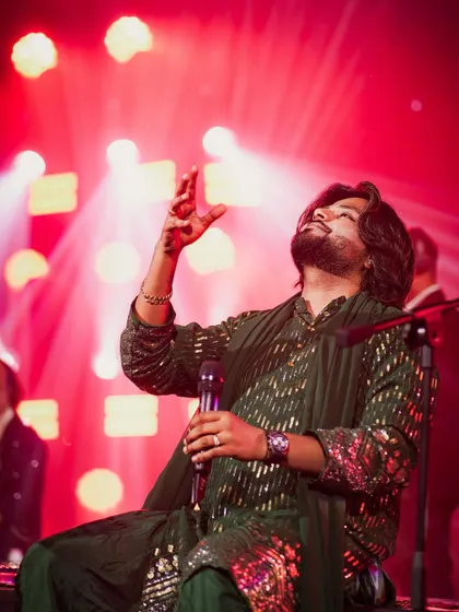 A moment of pure 'roohaniyat' or spirituality on stage. This is me, lost in a high note, connecting with the divine through music under the vibrant red lights.