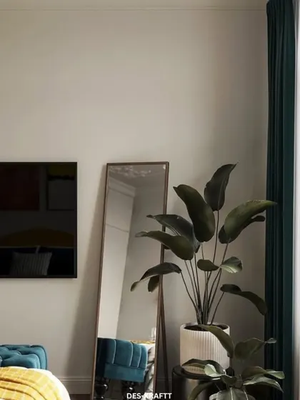 A full-length mirror and a large plant add life and dimension to this corner of the bedroom, reflecting the room's colorful and dynamic energy.