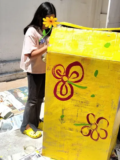 A child carefully paints a prop for the school play. This multidisciplinary project integrated art, literature, and performance, showing how learning can be deeply interconnected.