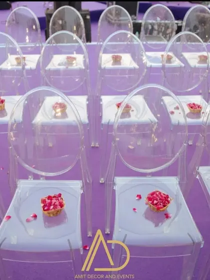 The little details matter. Here, small floral arrangements are placed on transparent ghost chairs for the wedding ceremony.