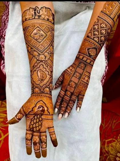 A royal-themed design with elephants at the top, a kalash symbol, and a prominent peacock on the palm.