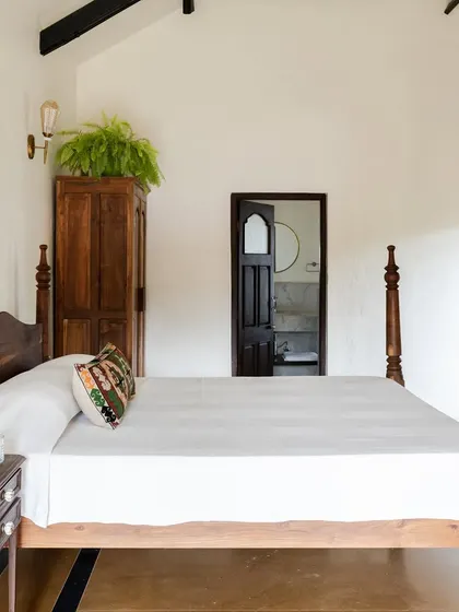 A bedroom in Maison Rouge featuring a refurbished antique four-poster bed. We believe in blending old and new, and this room is a perfect example of how we honor a family's history while creating a comfortable, modern living space.