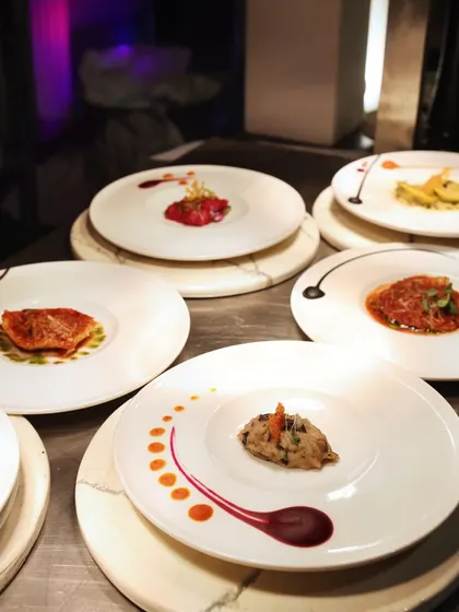 A collection of our artistically plated dishes, ready for service. Each plate is a unique composition, yet together they represent a cohesive culinary vision.