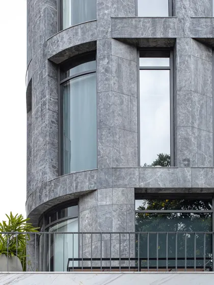 The curved corner of The Afyon Pavillion, clad in Afyon Grey marble. This detail demonstrates the technical skill required to apply a rigid material to a fluid form, resulting in a sophisticated and elegant facade.