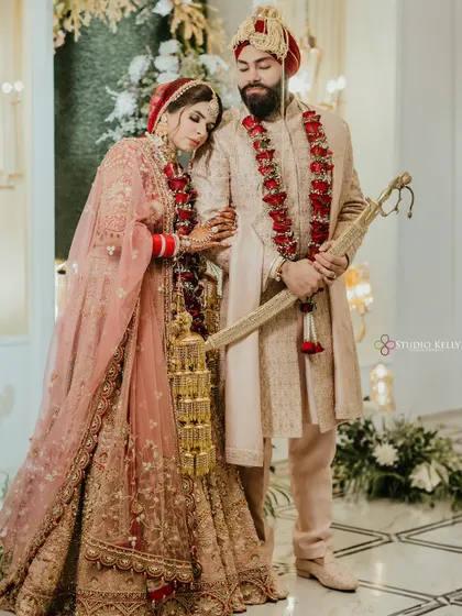 A serene portrait of a Sikh couple, the bride resting her head on the groom's shoulder, at their elegant wedding.