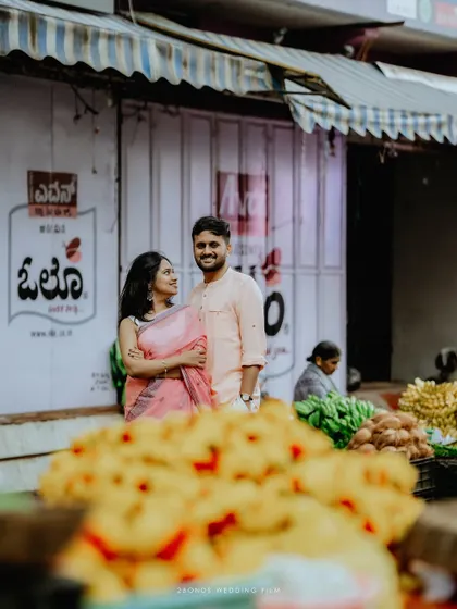 A creatively framed shot of the couple in the market, with colorful flowers in the foreground, adding depth and context to their urban love story.
