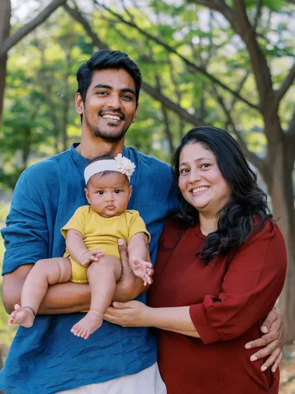 A family portrait with their new baby. The colors of their outfits complement each other and the natural surroundings beautifully.
