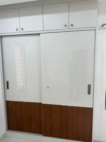 A modern sliding wardrobe with a two-tone design of white and wood. Sliding doors are an excellent choice for bedrooms where space is a constraint.