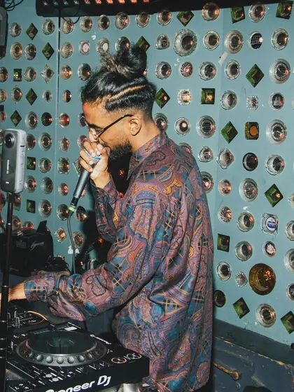 On the mic and in the mix. This shot captures me engaging with the crowd while lining up the next track. It's a constant flow of energy.