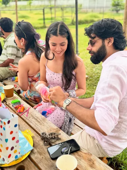 A candid moment of guests enjoying themselves at a picnic table during a birthday celebration. Our events are designed to be a great social outing for everyone.