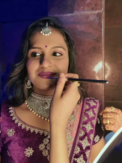 A behind-the-scenes moment of me applying the final touches to Lakshmi's reception lip color.