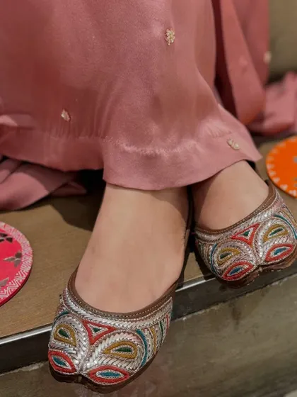 For those who love color, these juttis feature beautiful multi-colored threadwork in a geometric pattern, making them a standout accessory.