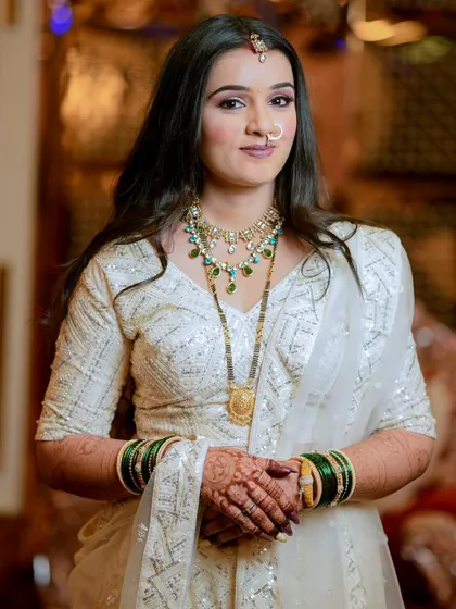 A direct and confident bridal portrait. The bride's poise and beautiful white outfit are the centerpiece of this shot.