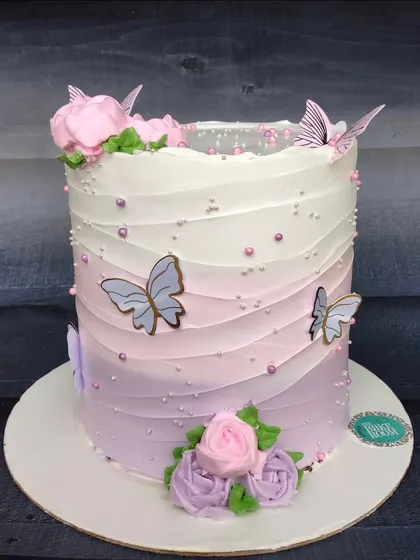 A Pinterest-perfect ombre cake in shades of purple and pink. The wavy texture and delicate butterfly accents make this a dreamy and elegant choice for any celebration.