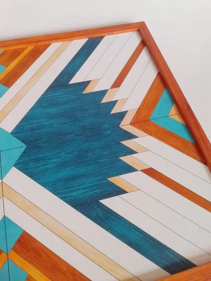 This angled close-up of the blue Aztec art highlights the clean lines and vibrant color combination of teal, orange, and white.