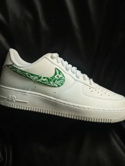 A clean white Nike Air Force 1 with a green paisley pattern filling the swoosh.