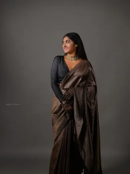 A full-length view of the bronze tissue saree, showing its beautiful sheen and elegant drape.