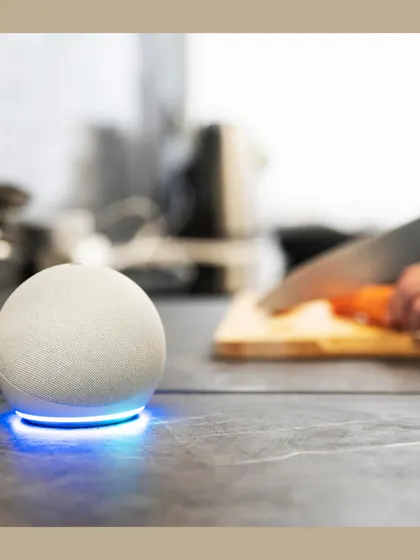 An Amazon Echo Dot sits on a kitchen counter, ready to assist with timers, recipes, or music, seamlessly blending into your daily life.