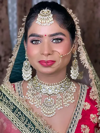 A beautiful bridal portrait of my hairstylist Nisha, showcasing a flawless look on her dusky skin tone. The pink and green outfit is complemented by soft glam makeup.