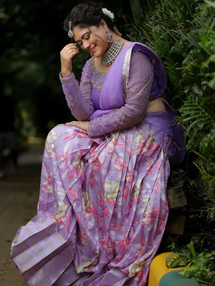 A candid, happy moment from a photoshoot. The model wears a modern silver-finish choker that pairs beautifully with this floral lavender saree.