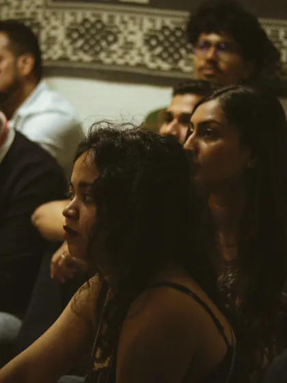 The audience, a mix of friends and fellow musicians, completely engrossed in the performance. This is the supportive community vibe we cultivate at Rainbow Bridge.