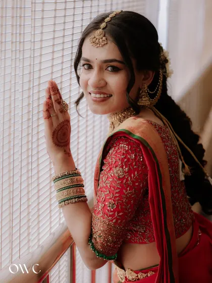 A close-up of the bride's happy face and her hand showing off the intricate henna design.