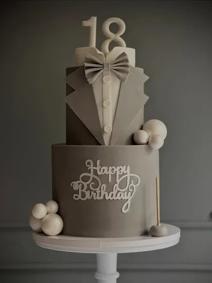 Perfect for an 18th birthday or a groom's cake, this two-tiered "tuxedo" cake is a masterclass in sharp edges and clean fondant work.